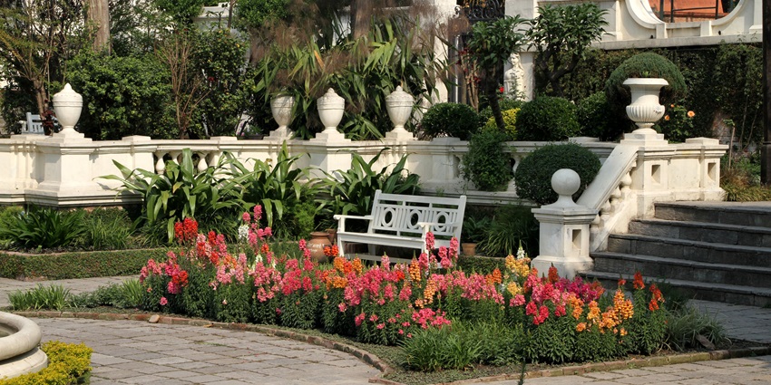 An image of an elegant neoclassical Garden of Dreams with pavilions, fountains, and lush greenery.