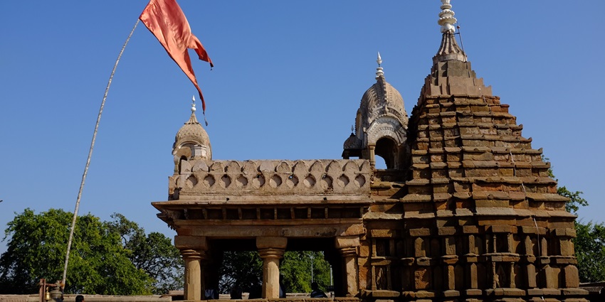 A picture of a traditionally built Shiva temple in Sikar, Rajasthan with a tall flag