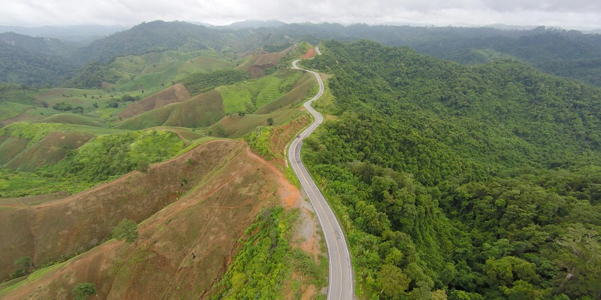 Aerial view of a road passing through the lush dense hills of the Lambasingi