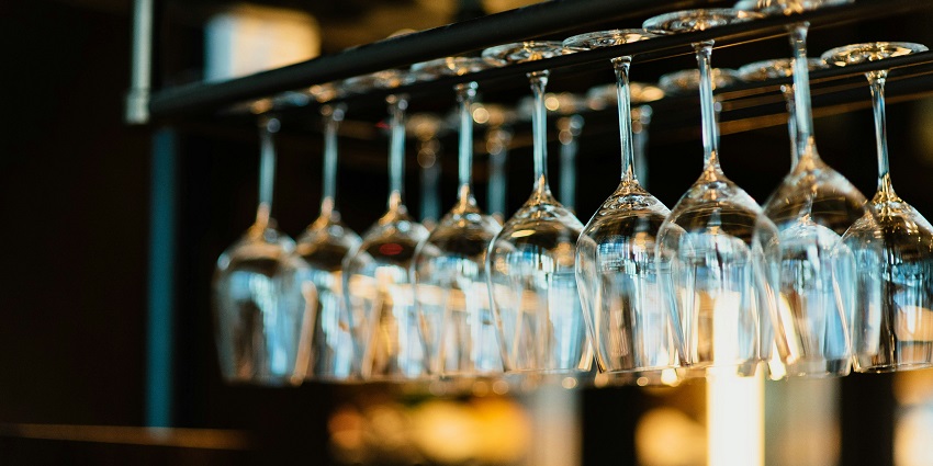 A row of beautifully decorated glasses lined up on a bar, vibrant colours and designs.