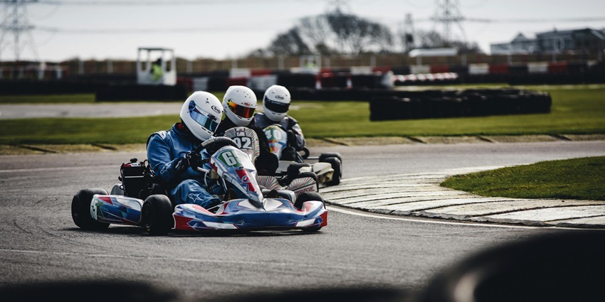 Three men racing in go-karts on a track, best things to do in Mumbai for youngsters.