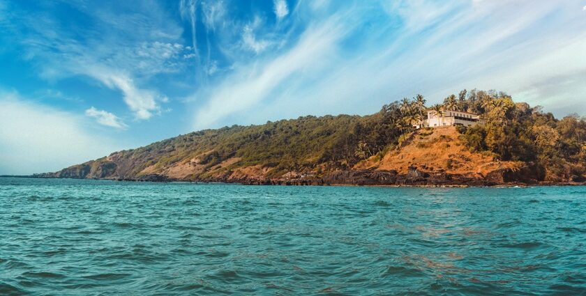 A glimpse of turquoise-blue waters surrounding an island decked with tall palm trees.