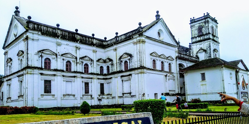 A traditionally architected building with a big garden in its surroundings
