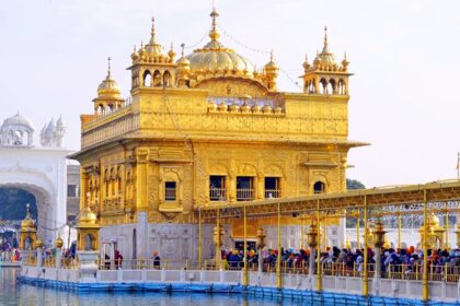 Punjab Golden Temple under clear blue sky, devotees standing in a line - explore hill stations near punjab