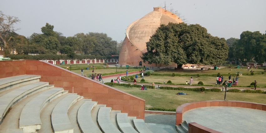 Huge domed shape granary with sitting place and platform surrounded by trees in view