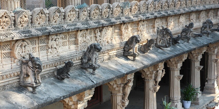 A picture of a historical palace in Gujarat with intricate carvings and traditional designs
