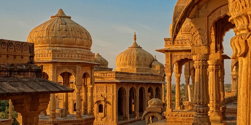 Golden hour view of the temple with domes and intricate architecture in a serene setting.