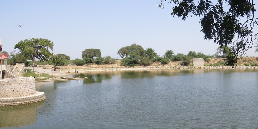Scenic the view of the serene waters of Gopi Talav surrounded by trees