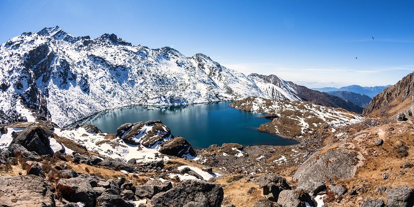 A picture of a lake surrounded by snow-capped mountains, one of the best places to visit in Nepal for couples