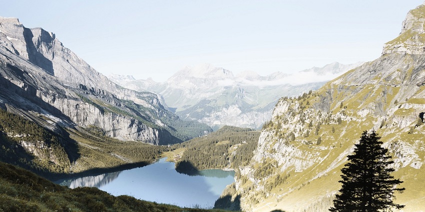 Tents set up in a mountainous area, surrounded by rugged terrain and clear skies, ready for adventure