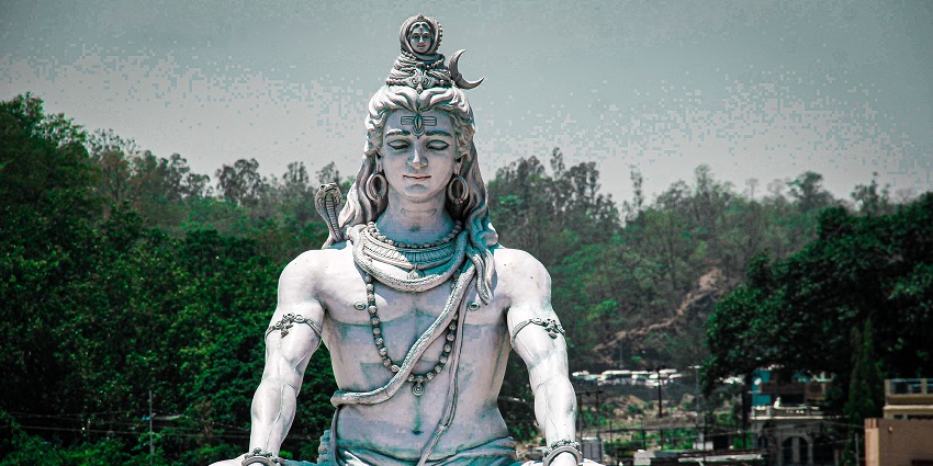 A metallic statue of the Hindu god Lord Shiva depicting a peaceful state of meditation.