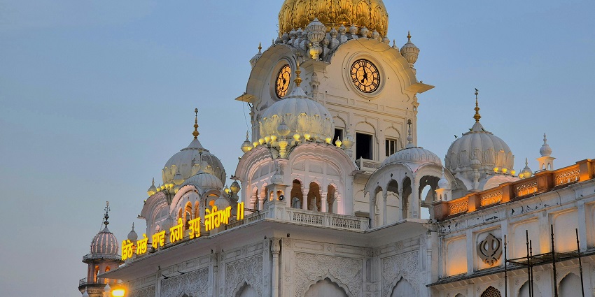 A large building with a domed roof and gold dome, representing architectural grandeur and significance, a notable feature among the places to visit in Bathinda.