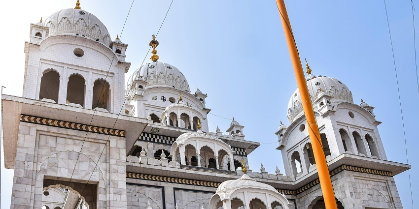 A picture of a gurudwara in Ludhiana with a sikh flag hoisted in front