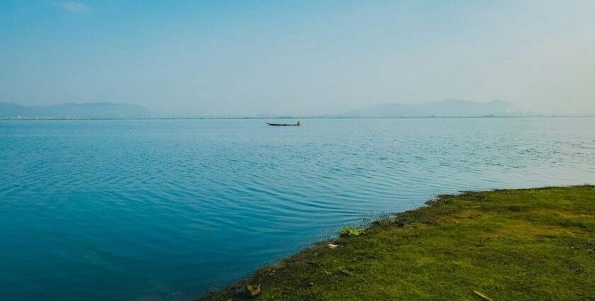 A glimpse of turquoise-blue waters of a lake meeting the lush green sprawling grounds.