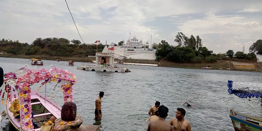 Gwarighat on the Narmada River with boats, temples, and peaceful riverside scenery