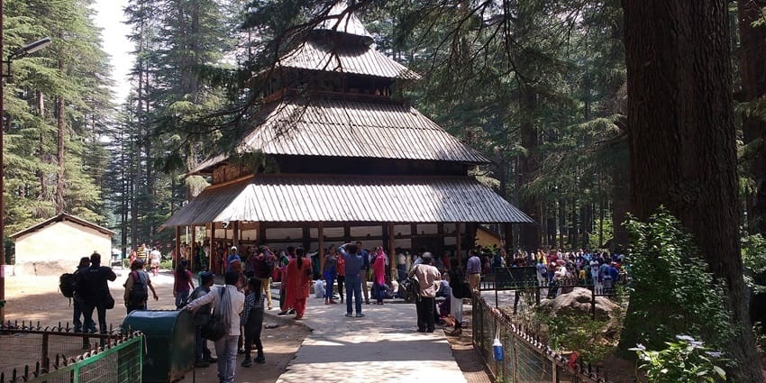 Hadimba Temple in Manali, surrounded by tall pine trees and traditional Himachali architecture