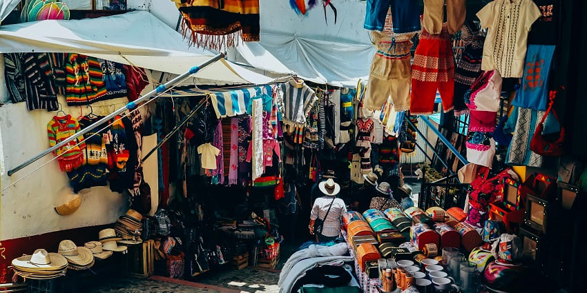 An image of the bustling Hall Bazaar with colourful textiles and traditional goods.