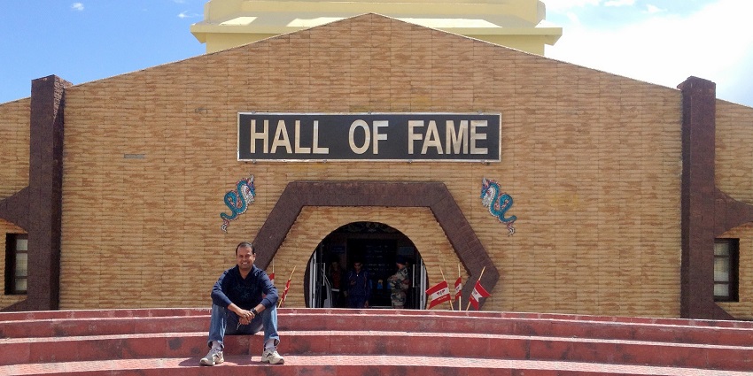 A person sitting outside the Hall Of Fame, dedicated to the Indian armed forces.