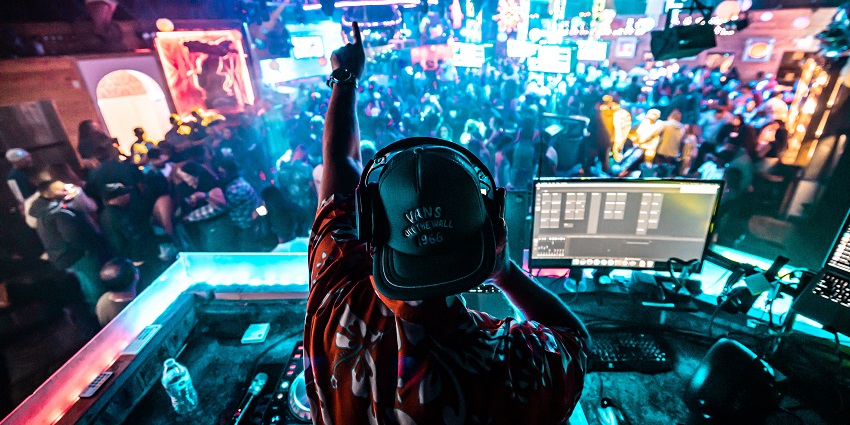 A picture of a DJ playing music at a nightclub in Goa for the excited crowd