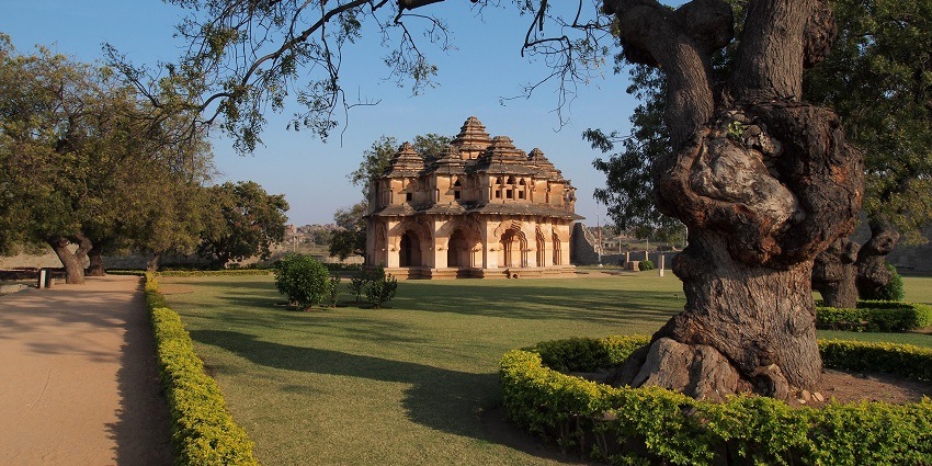 A picture of a historical monument in Goa with a garden area surrounding it