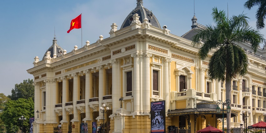 Elegant Hanoi Opera House with French colonial architecture, lit up at night.