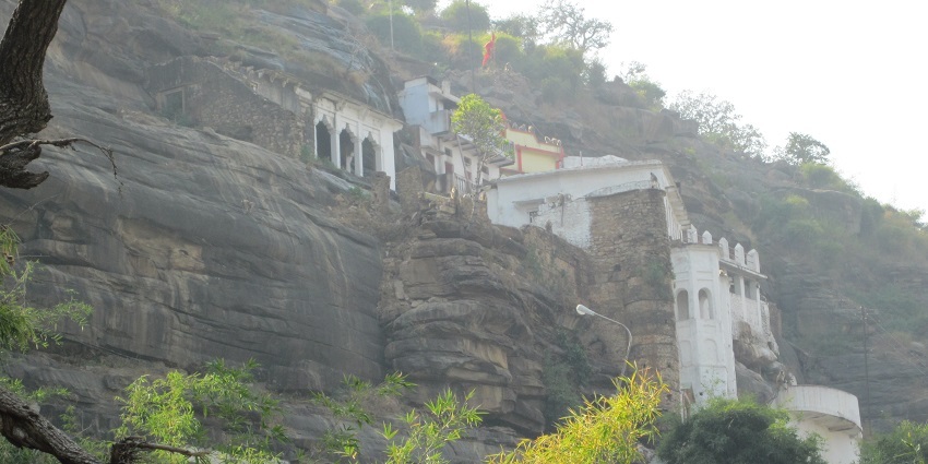 An image of Hanuman Dhara temple set against a lush green backdrop