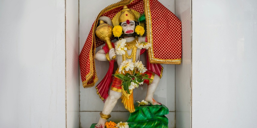 A detailed statue of a Hindu god nestled in a decorative niche, intricate craftsmanship.