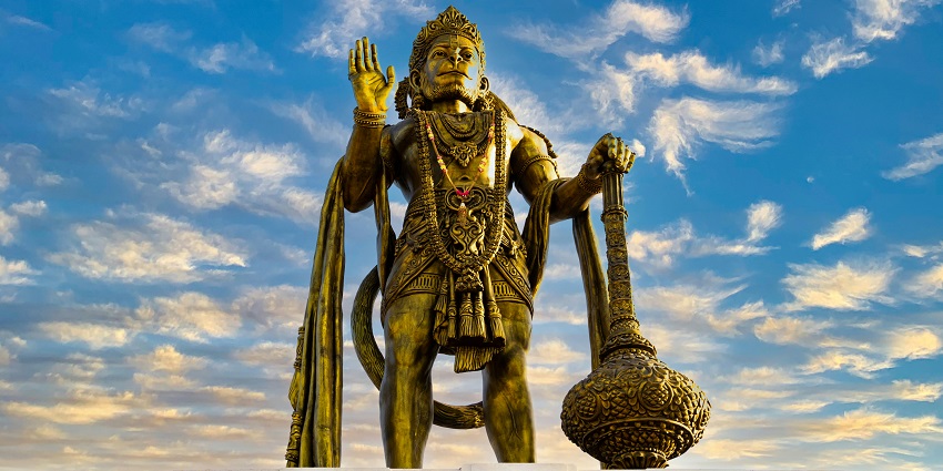 A detailed statue of Hanuman, the Hindu god, showcasing intricate carvings and vibrant colours.