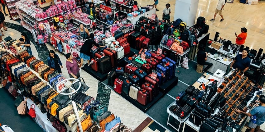 An aerial shot of the shop with luggage and items on display for sale with people.