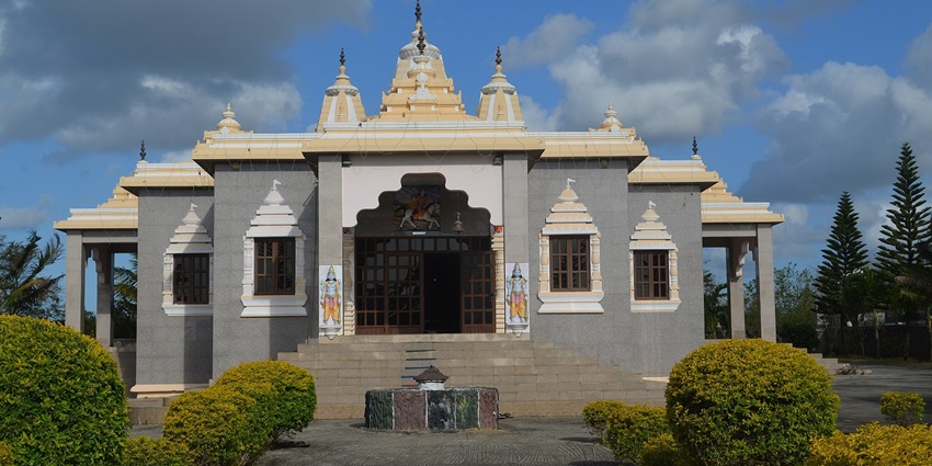 A frontal view of Krishna Temple in Gujarat surrounded by greenery.