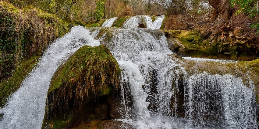 waterfall cascades through a lush green forest, creating a tranquil stream - hidden waterfalls in Goa