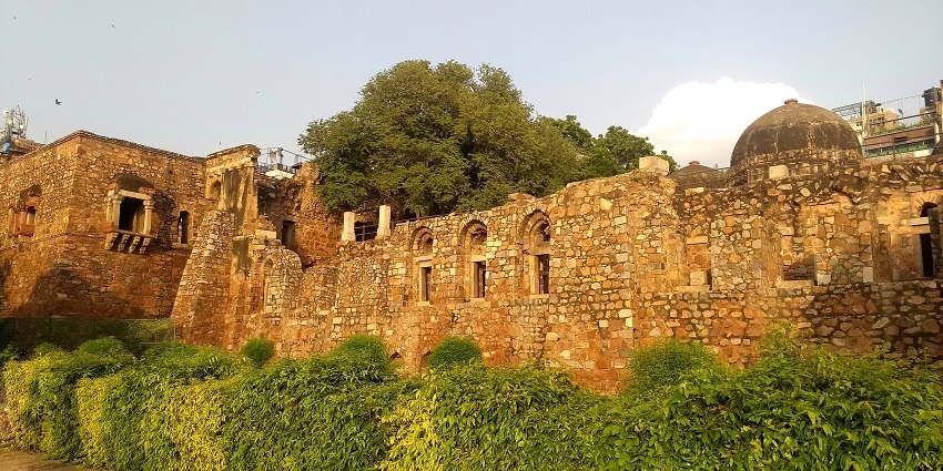 A picture of a traditionally made complex of a fort in Hauz Khas with a garden area around