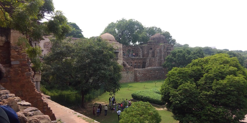 Image of Hauz Khas Village surrounded by lush greenery and the lake with cafes around