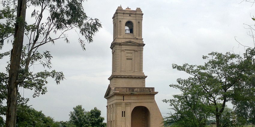 Picturesque view of the church tower standing amidst lush greenery