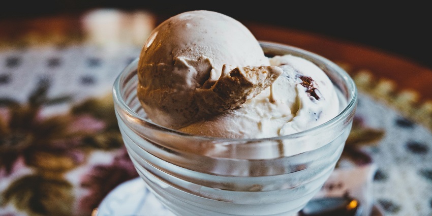 A chocolate sundae served in a glass, topped with whipped cream
