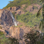 Picturesque view of a waterfalling caseding through big rocks - hidden waterfalls in Goa