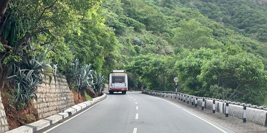 A highway winding through the lush landscapes of Andhra Pradesh, surrounded by greenery on both sides.