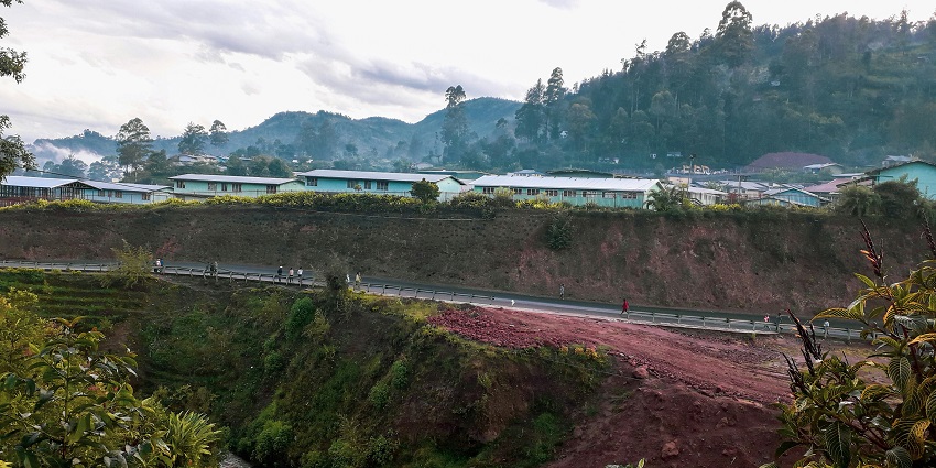 A picturesque mountain town with a river flowing through, surrounded by lush greenery.