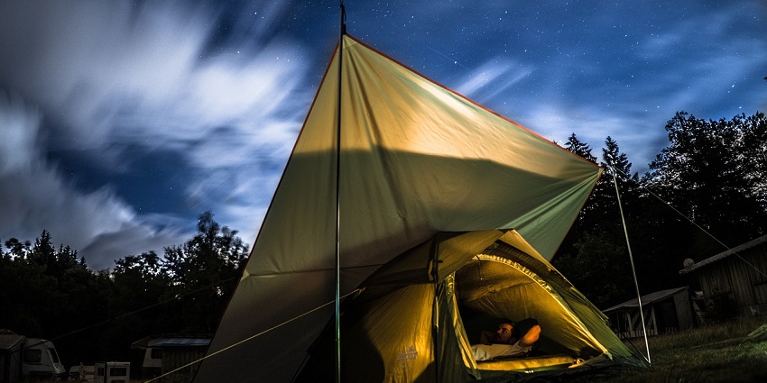 A tent set up in a serene nature setting, surrounded by greenery - camping in Dharamshala