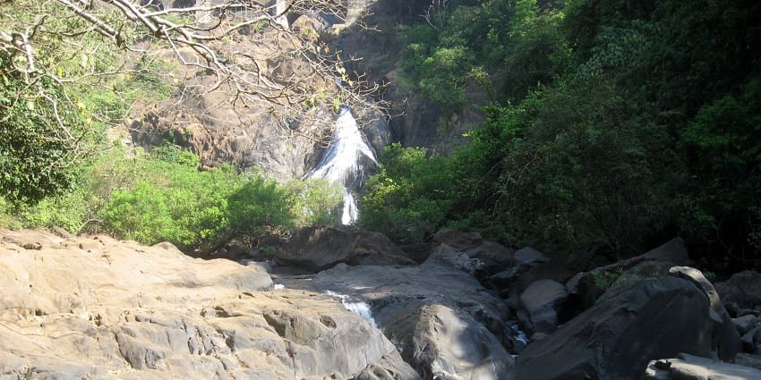 Scenic view of a waterfall pond surrounded by rocks - hidden waterfalls in Goa