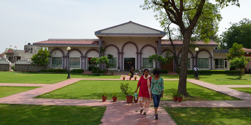 Dabchick Tourist Complex in Hodal, Haryana, showing a serene lake surrounded by greenery.