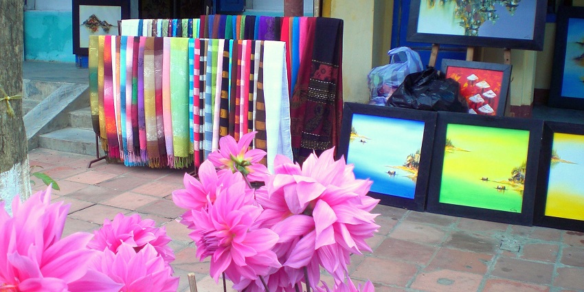 A vibrant silk and painting shop filled with colourful fabrics and artworks in Hoi An.