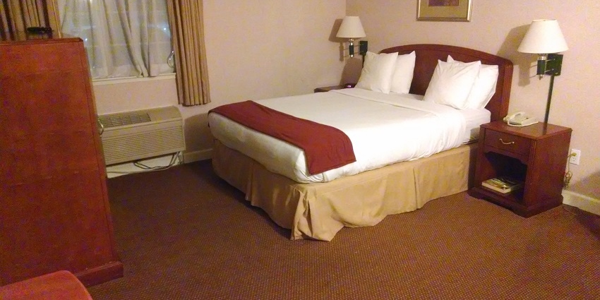 Snapshot from the inside of a hotel room with a beautiful bed and idyllic setting of surrounding