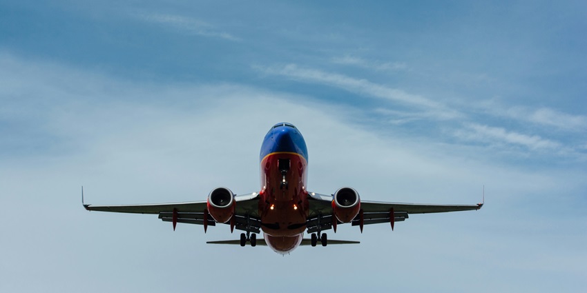A breathtaking view of a red and blue aeroplane flying in the sky during the daytime.