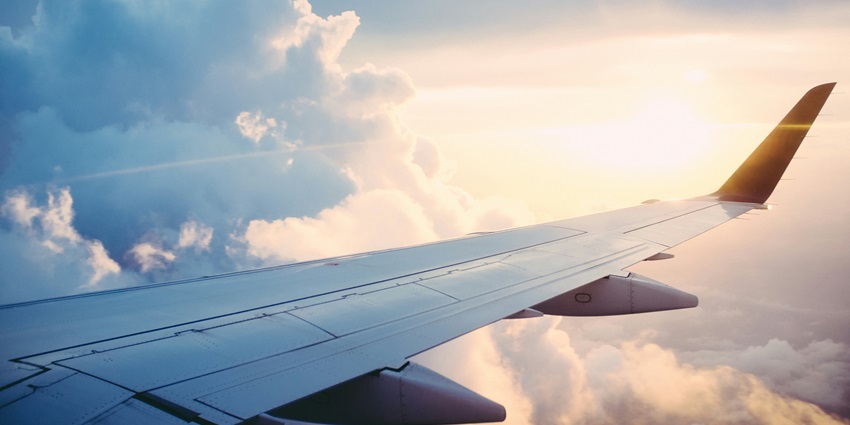 A stunning view of an aeroplane wing with dense clouds in the background during the day.