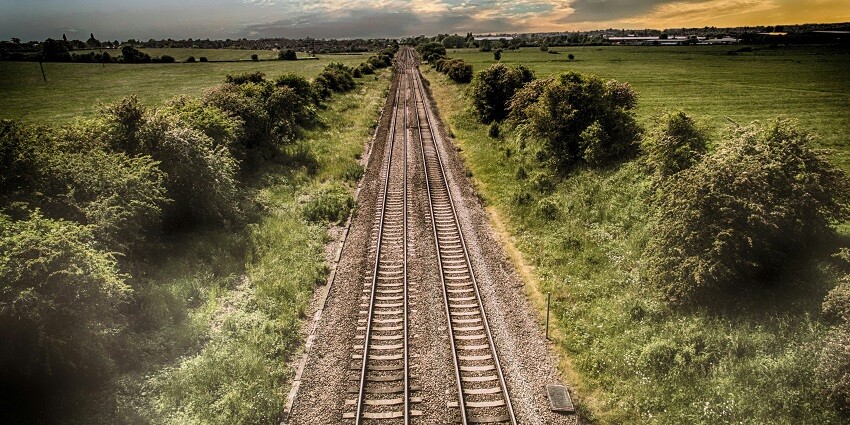 A breathtaking view of a railway track surrounded by lush greenery during the daytime.