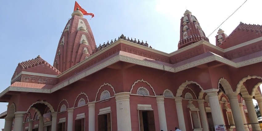 A picture of a temple with devotees approaching the entry gates