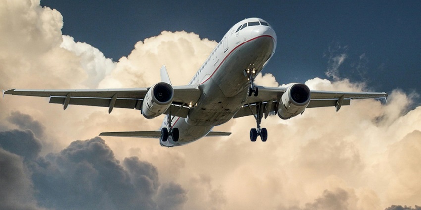 A breathtaking view of a white and red aeroplane flying in clear blue sky during the day.