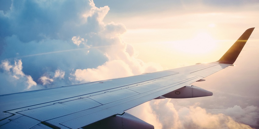 A breathtaking view of a clear blue sky with dense clouds from an aeroplane window.