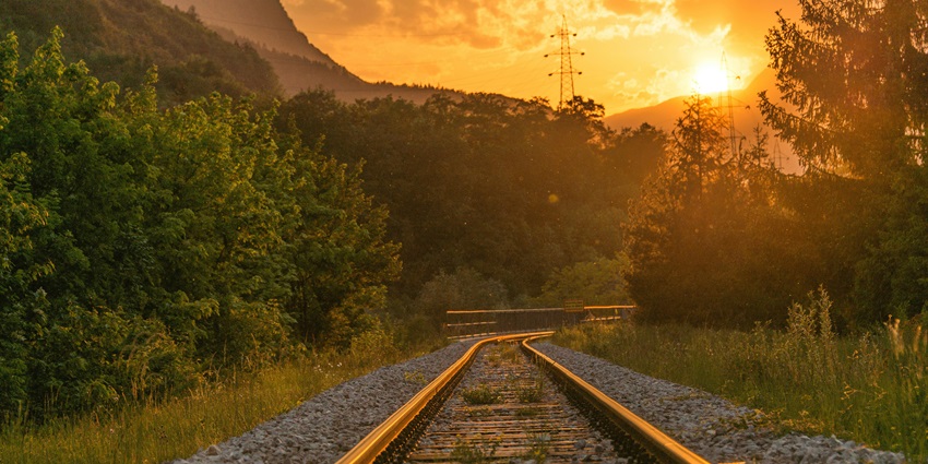 A stunning view of a railway track surrounded by lush greenery during the daytime.